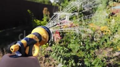 为<strong>花圃</strong>手工花园洒水器浇水的女人